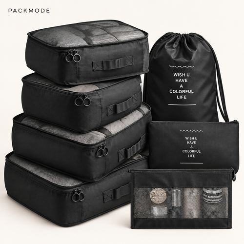 PACKMODE complete black seven-piece travel organizer set on warm ivory background